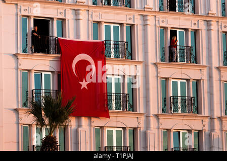 Izmir, Turkey - October 29, 2018: Turkish flag hanging on a building with two person at Alsancak Izmir Turkey. Stock Photo