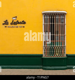 Yellow and green facade in the city center of Trujillo in colonial style architecture with cast iron window decoration, Peru. "The Select Tea Saloon". Stock Photo