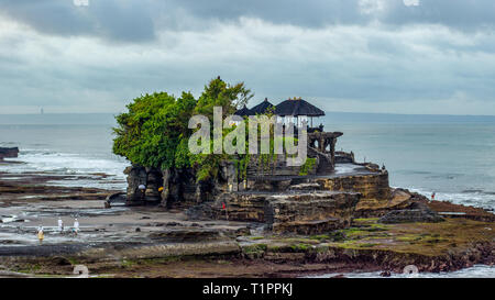 Early Morning at Tanah Lot Temple in Bali Indonesia. This picture is of some monks heading to the temple for prayer near a natural spring. Stock Photo