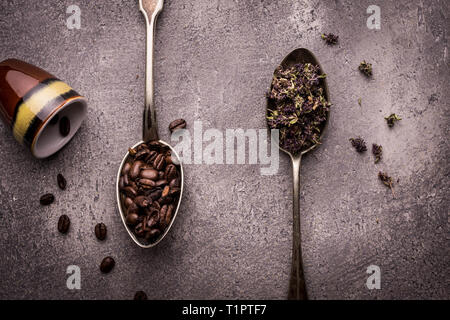 Tea and Coffee Beans in Rustic Spoons over Dark Stone Background Stock Photo