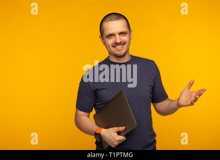Startuper man freelancer or developer smiling and holding laptop Stock Photo