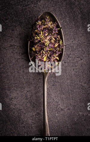 Dry Tea Leafs in Rustic Spoon on Dark Stone Background Stock Photo