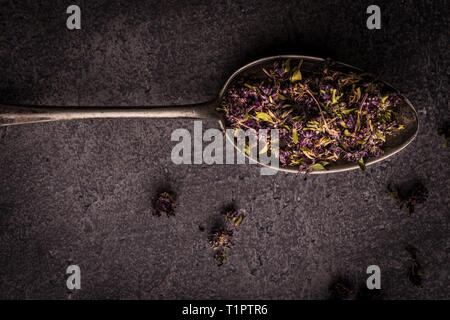 Dry Tea Leafs in Rustic Spoon on Dark Stone Background Stock Photo