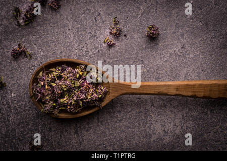 Dry Tea Leafs in Rustic Spoon on Dark Stone Background Stock Photo