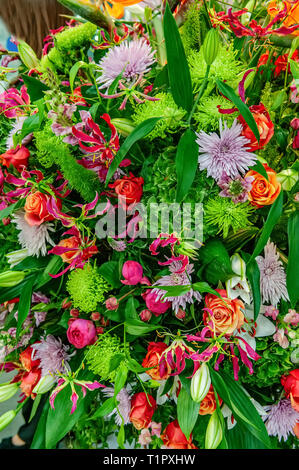 Beautiful large bouquet of chrysanthemums, orchids and gerberas with a big yellow lily in a flower shop. Stock Photo