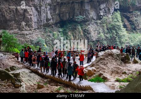Chongqing, China. 27th Mar, 2019. Tourists go sightseeing at the Tiansheng Sanqiao scenic area in Wulong District of Chongqing, southwest China, March 27, 2019. The Tiansheng Sanqiao scenic area, where three natural limestone arches look like bridges, is a popular tourist attraction. Credit: Liu Chan/Xinhua/Alamy Live News Stock Photo