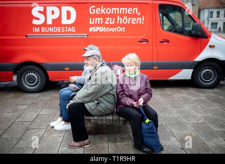 28 March 2019, Brandenburg, Eberswalde: Citizens sit on the market square of Eberswalde in front of an SPD bus with the inscription 'Come to hear'. Faction members and federal ministers tour Brandenburg, Mecklenburg-Western Pomerania, Saxony-Anhalt, Thuringia, Saxony, Bavaria and Baden-Württemberg. Until September a bus travels every week to a different federal state. Photo: Kay Nietfeld/dpa Stock Photo