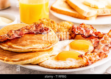 Healthy Full American Breakfast with Eggs Bacon Pancakes and Latkes, selective focus. Stock Photo