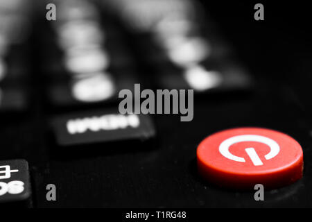 A closeup to the red power button of a remote control-telecontrol with bokeh effect Stock Photo