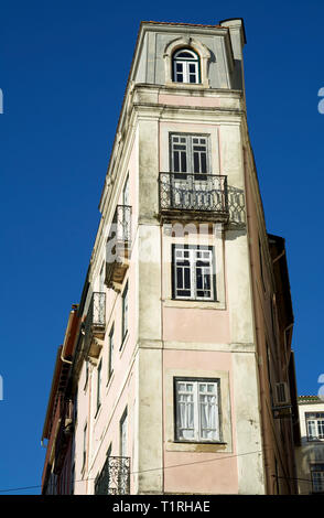 An extremely narrow multi-storey traditional  house in the old town of Coimbra (Portugal) set against a deep blue sky. Stock Photo