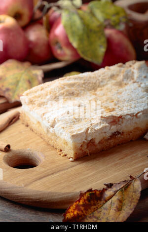 Fresh baked delicious classic American apple pie. Apples, cinnamon sticks and kitchen utensils on a old wooden table. Stock Photo