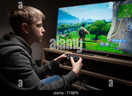 Teenage boy playing Fortnite Battle Royal computer game Stock Photo