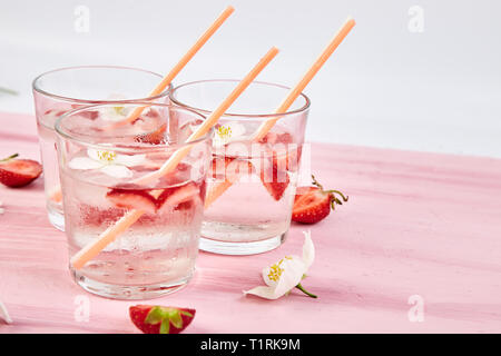 Strawberry detox water with jasmine flower. Summer iced drink or tea. Lemonade with berry. Flavored Water in glasses with Fresh Strawberry. Diet. Stock Photo