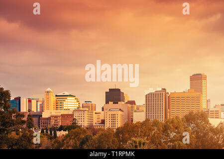 Adelaide city skyline viewed from stadium balcony across Elder Park on at sunset Stock Photo