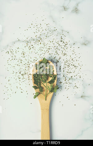 parsley in a wooden spoon against marble stone Stock Photo