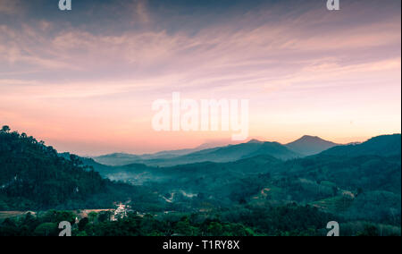 Beautiful nature landscape of mountain range with sunset sky and clouds. Rural village in mountain valley in Thailand. Scenery of mountain layer at du Stock Photo