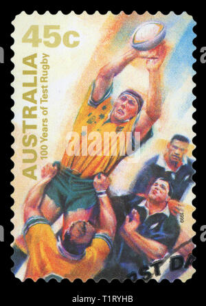 AUSTRALIA - CIRCA 1999: A Stamp printed in AUSTRALIA shows the Catching ball, 100 Years of Test Rugby, series, circa 1999. (Isolated on black) Stock Photo