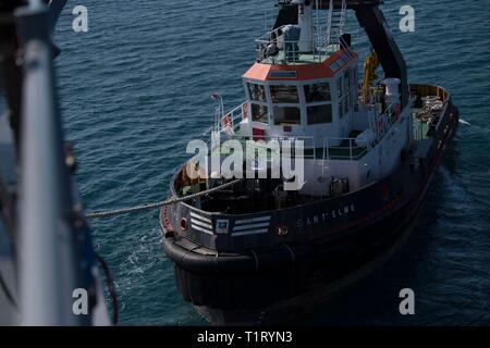 190323-N-GA520-0393      GAETA, Italy (March 23, 2019) – A tug assists the Blue Ridge-class command and control ship USS Mount Whitney (LCC 20) in docking pierside March 23, 2019.  Mount Whitney, forward deployed to Gaeta, Italy, operates with a combined crew of U.S. Navy Sailors and Military Sealift Command civil service mariners. (U.S. Navy photo by Mass Communication Specialist 1st Class Charles Hayes/Released) Stock Photo