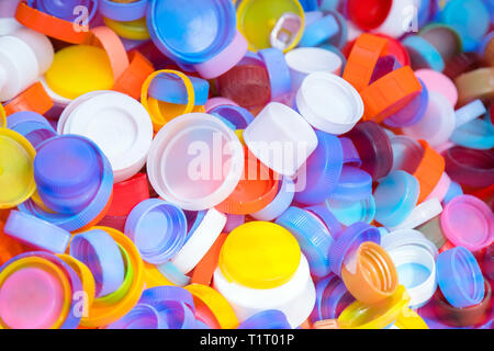 Pile of plastic bottle caps texture. A lot of bottle tops of soft drinks, plastic recycling Stock Photo
