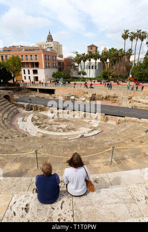 Tourists at the ruins of El Teatro Romano, or Roman Theatre, built in the 1st century BC, Malaga old town, Malaga Spain Stock Photo