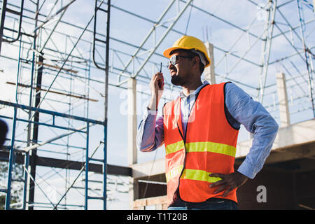 engineer holding radio and ordering at construction working site Stock Photo