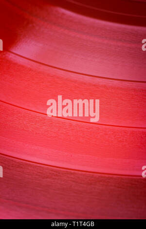 Close up of red vinyl surface. Red vinyl record texture background. Close up of vinyl LP record showing grooves Stock Photo