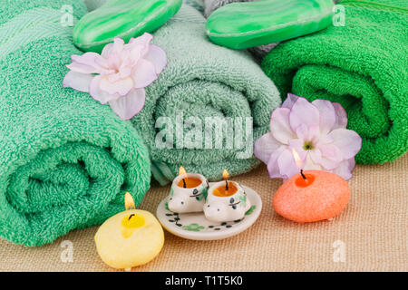 Spa set with towels, candles, soaps and flowers on bamboo background. Stock Photo