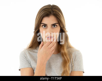 Surprised young woman in her twenties feeling afraid covering mouth in shock reaction, looking with fear in her eyes. People and Human expressions and Stock Photo