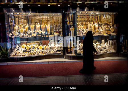 muslim woman in burqa view the windows in the gold souk in Dubai Stock Photo