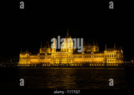BUDAPEST, HUNGARY - MAR 07th, 2019: The Hungarian Parliament Building is the seat of the National Assembly of Hungary at the Danube river during night Stock Photo