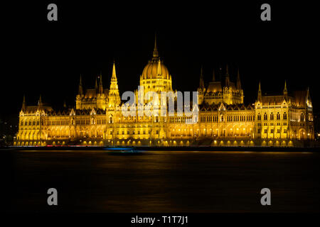 BUDAPEST, HUNGARY - MAR 07th, 2019: The Hungarian Parliament Building is the seat of the National Assembly of Hungary at the Danube river during night Stock Photo