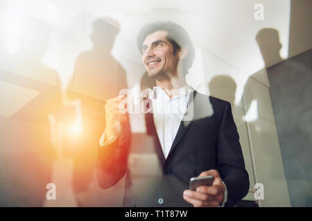 Businessman works with his smartphone in office. double exposure. Stock Photo