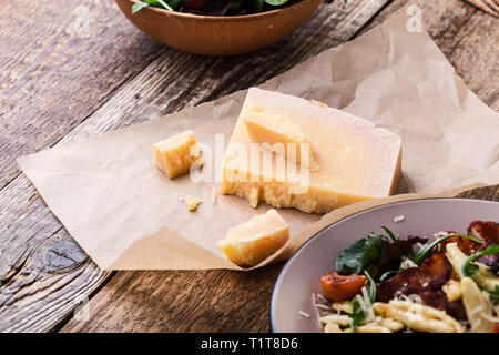 Parmesan cheese on rustic wooden table, traditional Italian cuisine ingredient, close up, selective focus Stock Photo