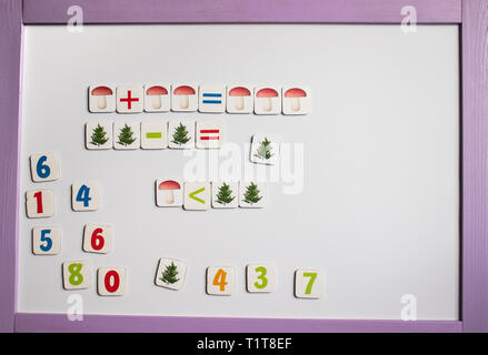 Alphabet letters and numbers. Against the background of the white school board. Preparation for school. The concept of education and school life. Stock Photo