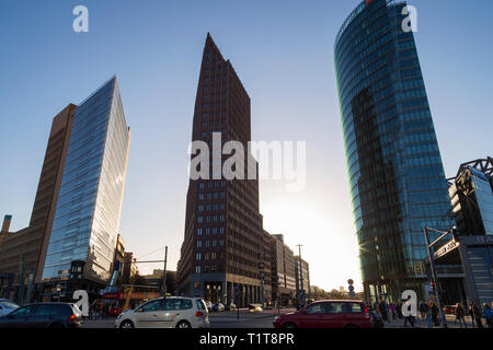 Modern high-rise buildings against clear blue sky and people and cars on the streets at Potsdamer Platz in downtown Berlin, Germany, on a sunny day. Stock Photo