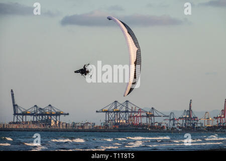 Valencia port background, Spain Motor paragliding Paraglider flying above the Mediterranean sea coast, Docks and Harbour back Stock Photo