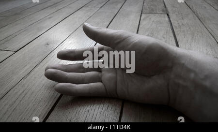 Male hand resting against wooden floor Stock Photo