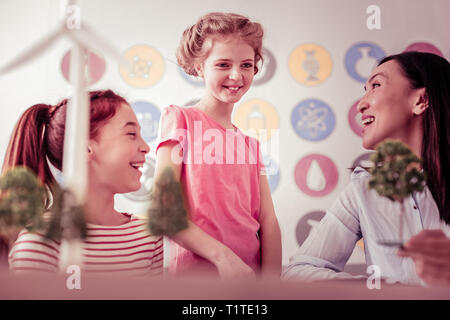 Shy cute schoolgirl looking on the model of the farm Stock Photo