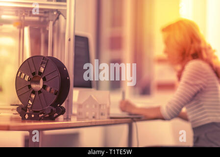 Focused reliable woman being engrossed in her work in the background. Stock Photo