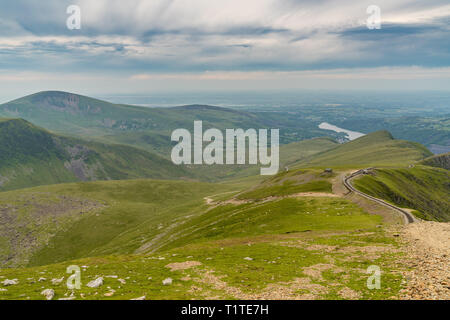 Walking down from Mount Snowdon on the Llanberis Path, Snowdonia, Gwynedd, Wales, UK - looking north towards the Clogwyn station, Llyn Padarn and Llan Stock Photo