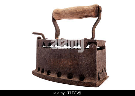 Close up of an antique and rusty iron from coal ironing with wooden handle, isolated on white background. Houseworks. Laundry. Stock Photo