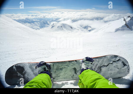 Point of view shot of a male snowboarder lying on the snow on the slope relaxing after riding Stock Photo