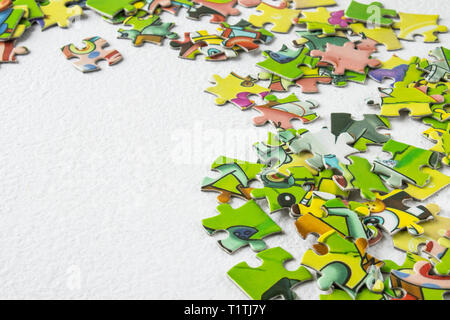 Puzzles scattered on a light table with the right close-up. Educational game for children and adults. There is a place for your text. Copy Space. Stock Photo