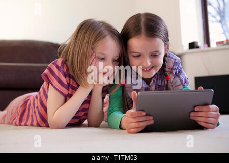 Two happy children using a tablet device together Stock Photo