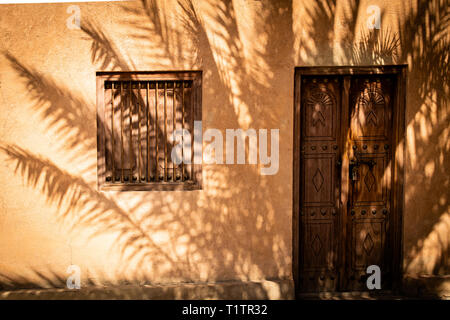 A palm is throwing its beautiful shade on the front of a house in UAE, Al Ain. Stock Photo
