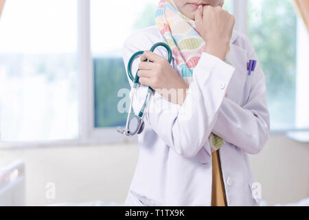 muslim female doctor with stethoscope posing in front of camera inside comfortable hospital room Stock Photo
