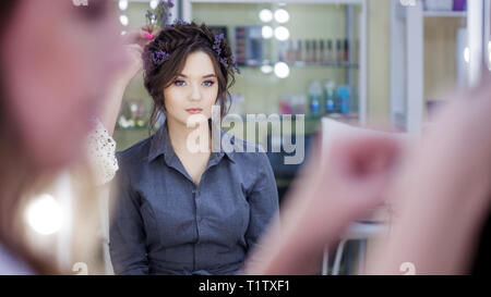 Stylist makeup artist doing makeup and hair in a beauty salon. Professional make-up, master of image creation. Stock Photo