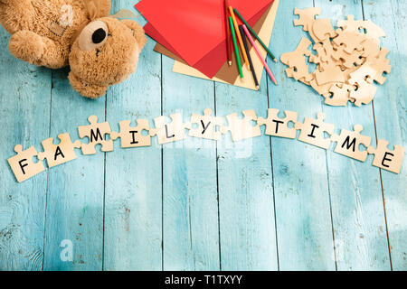 Stationery and words FAMILY TIME made of letters, mock up and pieces of puzzles on wooden background. Health, success, mother, happy, life, love, happiness, lifestyle, togetherness concepts Stock Photo