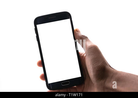 Man hand holding the black smartphone with big blank screen and modern frame less design - isolated on white background angled position - Image Stock Photo