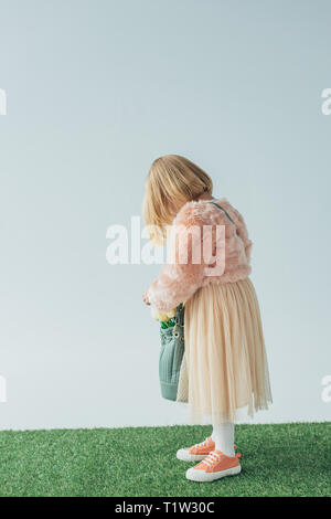 side view of girl holding bag with white tulips isolated on grey Stock Photo